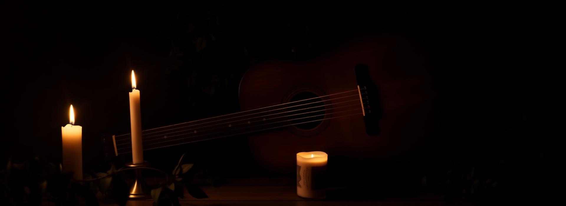 Acoustic guitar with candles in warm light